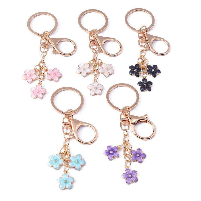 Wholesale Cherry blossom metal keychains available in various colors.