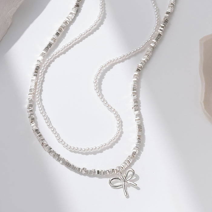 Wholesale Cross border new bow necklace with simple and high-end feel, retro double-layer layered design, imitation pearl collarbone chain
