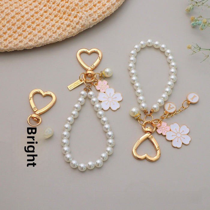 Wholesale Two tone flower alloy keychain pendant, cute letters, pearl accessories, headphone cover, bag, hanging decoration