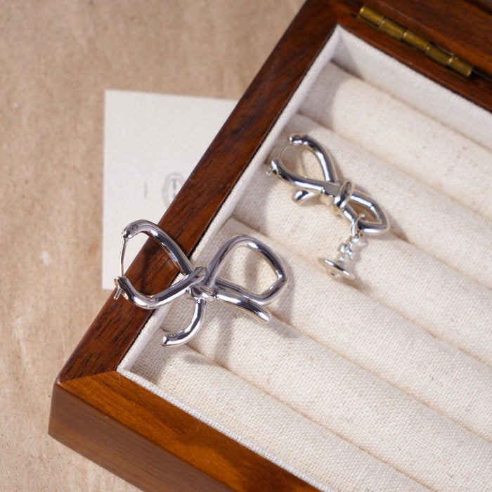 Wholesale Asymmetric bow, small Saturn, gold and silver earrings, niche design, light luxury