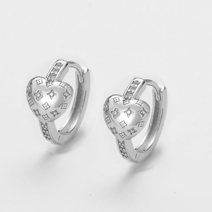 Wholesale Zirconia-studded heart-shaped metal earrings with a patterned design.