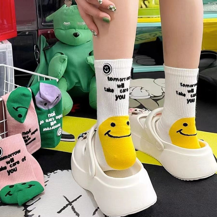 Wholesale Colorful socks with smiley face and letter print on the outside, with a pile of socks in the middle