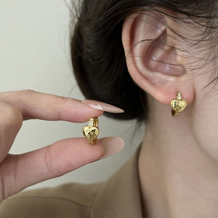Wholesale Zirconia-studded heart-shaped metal earrings with a patterned design.