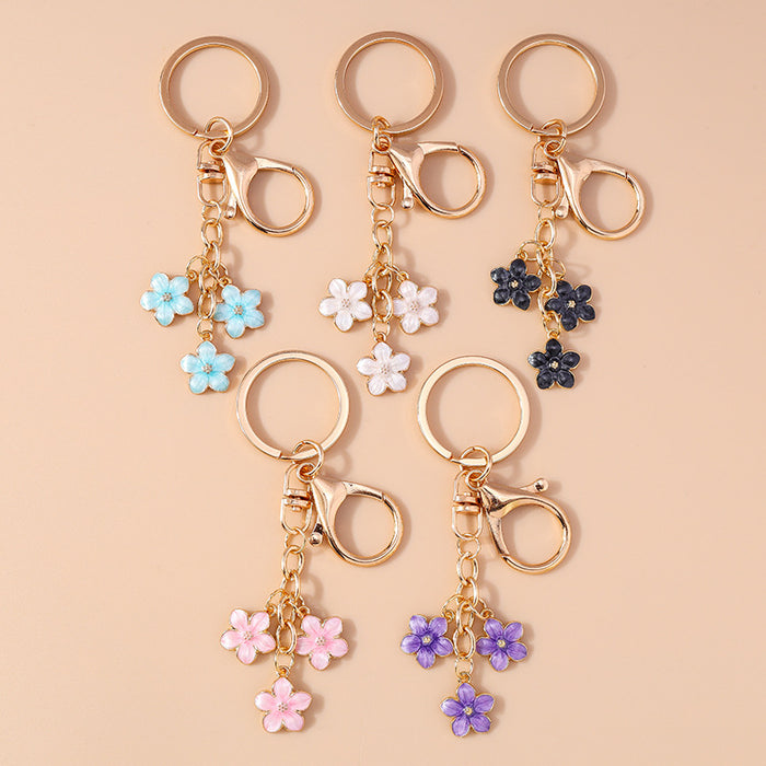 Wholesale Cherry blossom metal keychains available in various colors.
